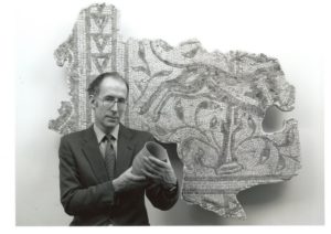 Dr Paul Robinson, FSA. Photographed at the Museum with a Roman mosaic from Cherhill and holding a replica Bronze Age Beaker