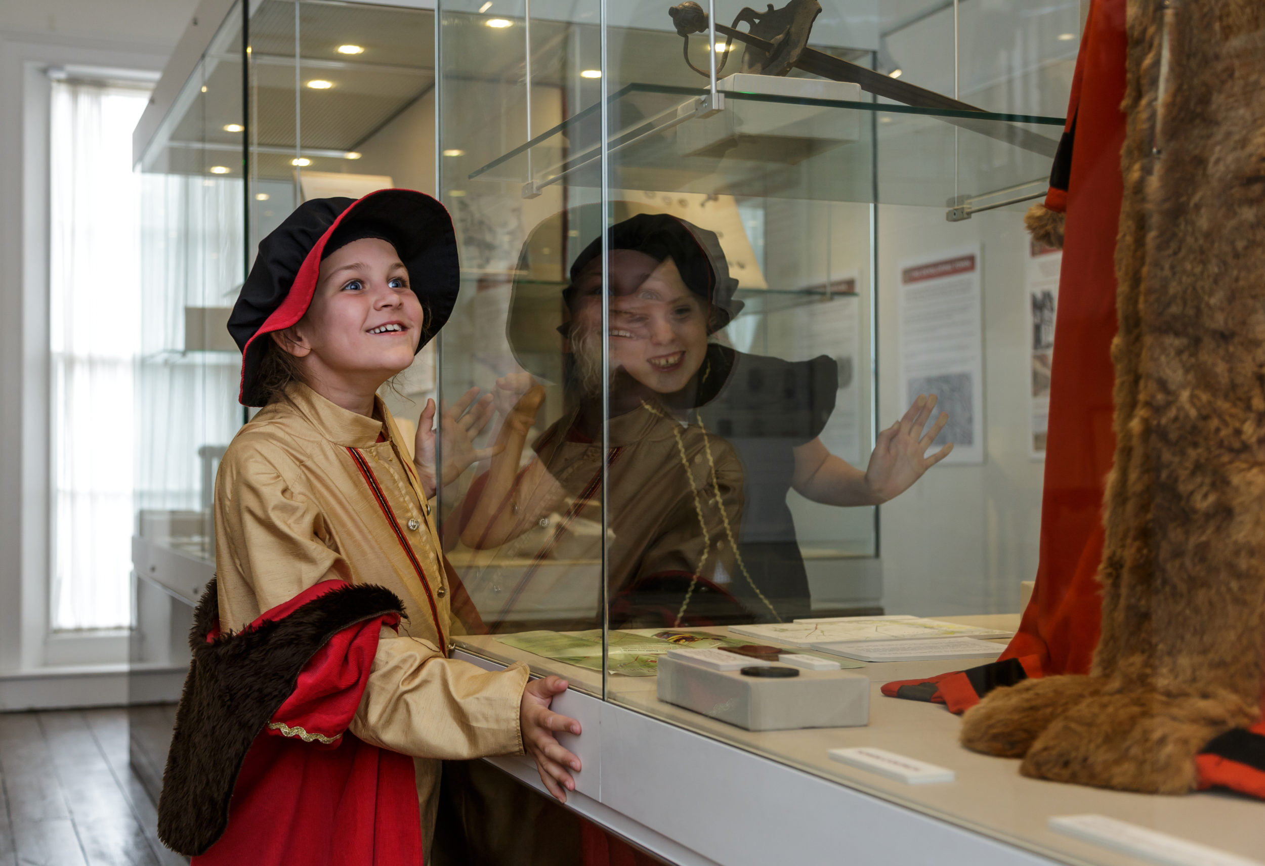 Children in costume looking at objects on display in the Story of Devizes Gallery