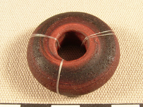 A small circular glass bead with a hole in the centre