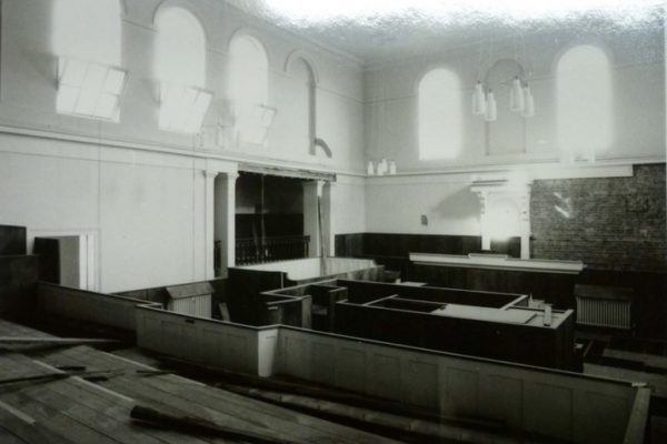 Interior view Court 1 - the AssizeCourt. Judge's throne and Grand Jury box. Plaster stripped from part of the wall show that the Court is no longer in use.