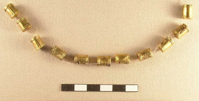 Gold necklace of 11 drum-shaped beads, suspended on a thread