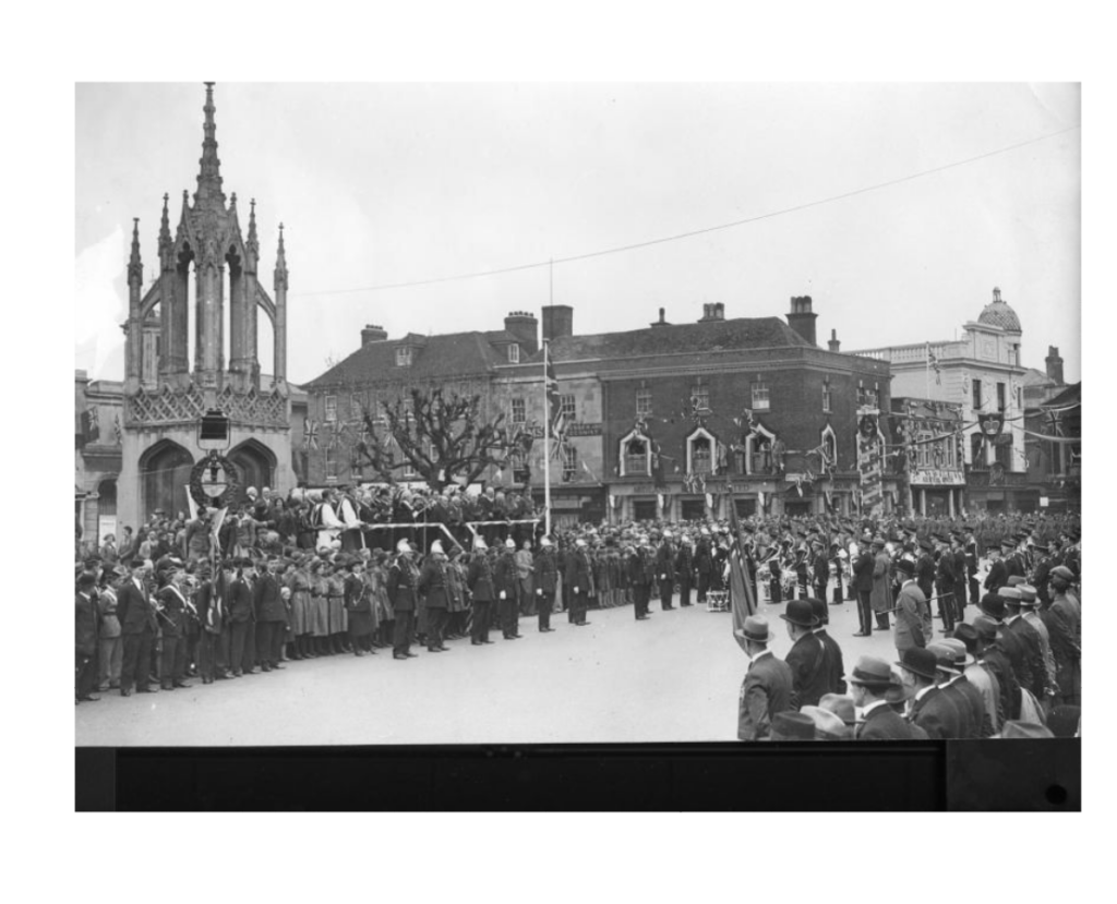 Photograph of a crowd of people lining each side of a street